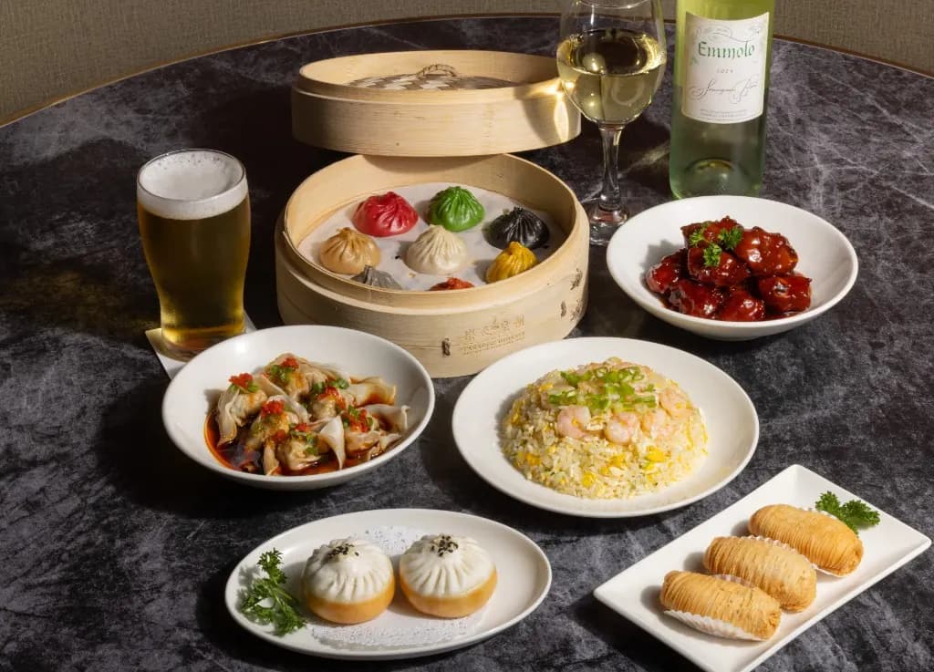 Happy hour plates of xiao long bao, fried rice, wontons, and buns with beer and wine
